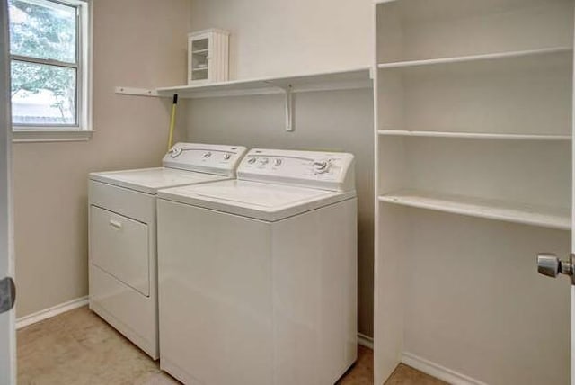 clothes washing area with baseboards, laundry area, and independent washer and dryer