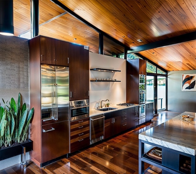 kitchen with open shelves, a sink, dark brown cabinetry, lofted ceiling with beams, and appliances with stainless steel finishes