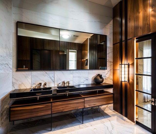 full bath featuring backsplash, double vanity, and marble finish floor