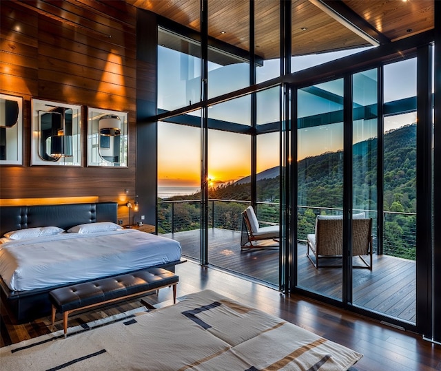 bedroom with a towering ceiling, wood walls, floor to ceiling windows, and hardwood / wood-style floors