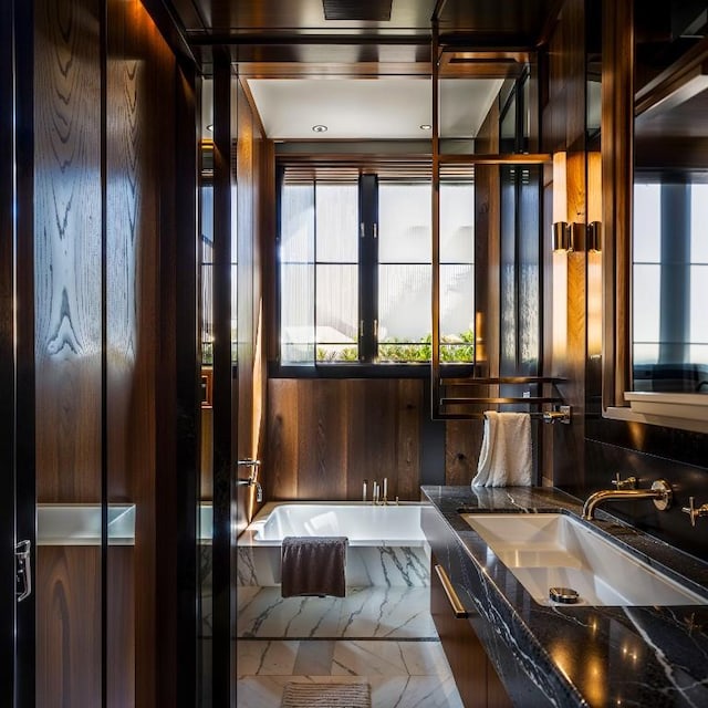 full bath with double vanity, a sink, and a bath