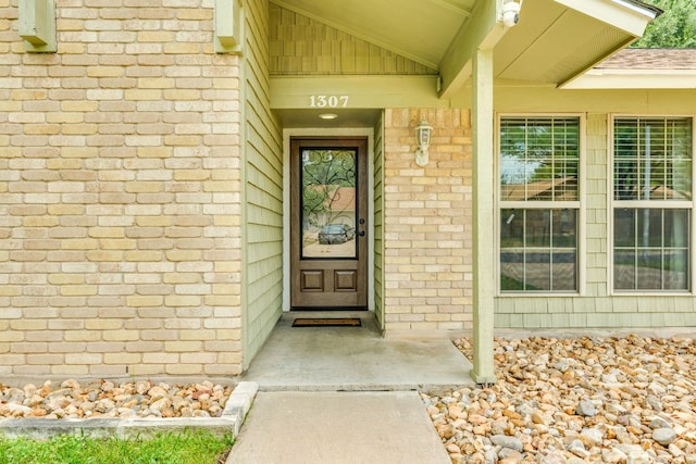 view of exterior entry with brick siding