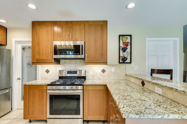 1307 S Meadows Dr, Austin, TX 78758 - kitchen featuring appliances with stainless steel finishes, light stone countertops, brown cabinets, and recessed lighting