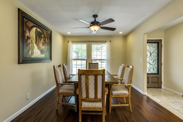dining space with baseboards, a ceiling fan, and wood finished floors
