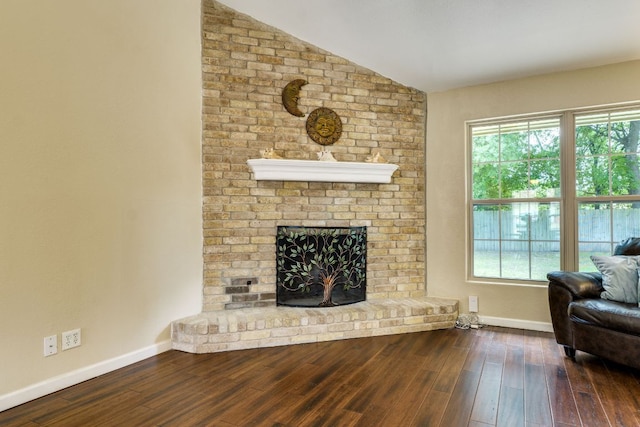 1307 S Meadows Dr, Austin, TX 78758 - living area featuring baseboards, vaulted ceiling, wood finished floors, and a brick fireplace