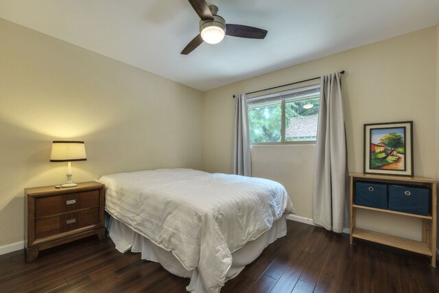 bedroom with dark wood-type flooring, baseboards, and ceiling fan