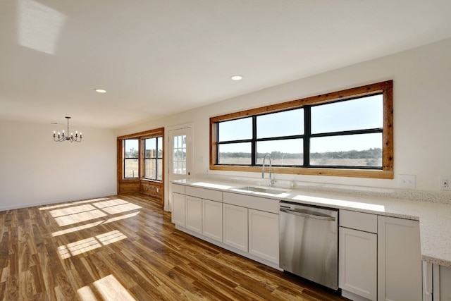 kitchen with a sink, a notable chandelier, wood finished floors, and dishwasher