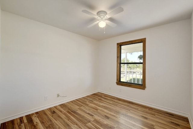 empty room with baseboards, a ceiling fan, and wood finished floors