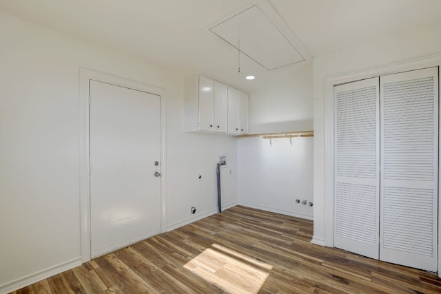 clothes washing area featuring cabinet space, hookup for a washing machine, gas dryer hookup, attic access, and wood finished floors