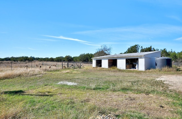 view of yard with a detached garage and an outbuilding
