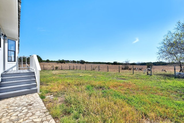 view of yard with fence and a rural view