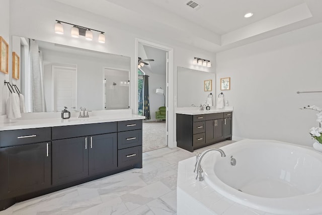 1504 Caylea Bluff Ln, Georgetown, TX 78628 - full bath with two vanities, a garden tub, a ceiling fan, recessed lighting, and a walk in shower