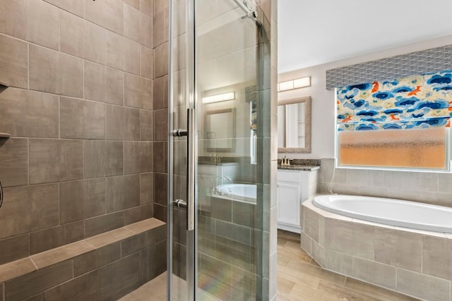 bathroom with vanity, wood finished floors, a garden tub, and a stall shower