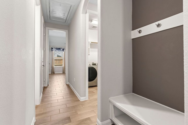 mudroom with baseboards, attic access, light wood finished floors, and washer / clothes dryer