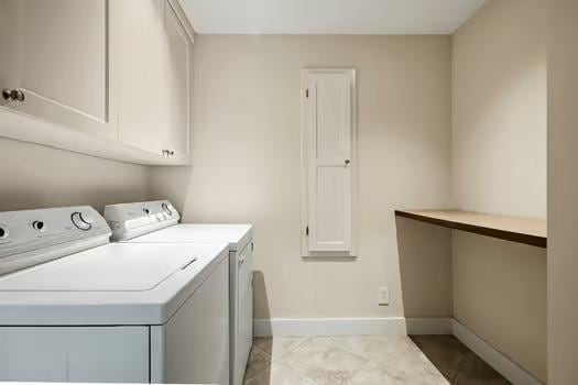 laundry room featuring cabinet space, separate washer and dryer, and baseboards