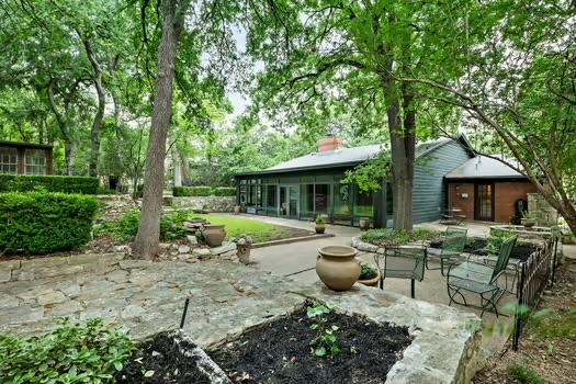 rear view of property with a chimney, a sunroom, and a patio area