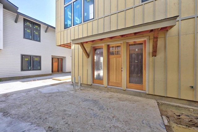 property entrance featuring board and batten siding and a patio area