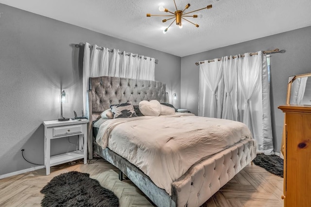 9623 County Road 347, Caldwell, TX 77836 - bedroom with baseboards, a textured wall, a textured ceiling, and a notable chandelier
