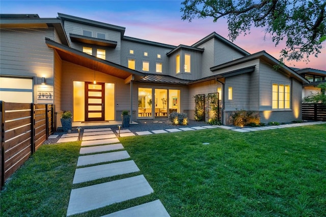 2902 Cedarview Dr, Austin, TX 78704 - back of house at dusk featuring a yard, fence, a standing seam roof, and metal roof
