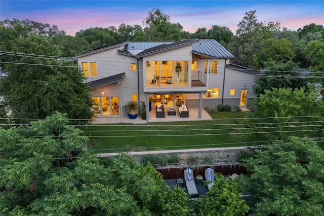2902 Cedarview Dr, Austin, TX 78704 - back of house with a balcony, a standing seam roof, a patio area, metal roof, and a lawn
