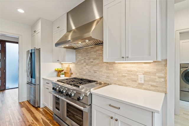 2902 Cedarview Dr, Austin, TX 78704 - kitchen with light wood-style floors, white cabinetry, wall chimney range hood, and stainless steel appliances