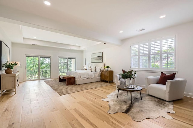 bedroom featuring visible vents, light wood finished floors, baseboards, and multiple windows