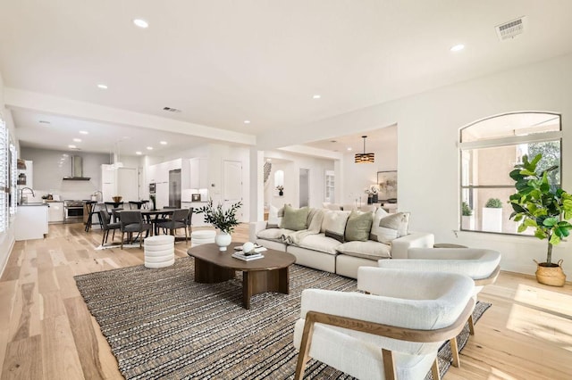 living area featuring light wood-style floors, recessed lighting, and visible vents