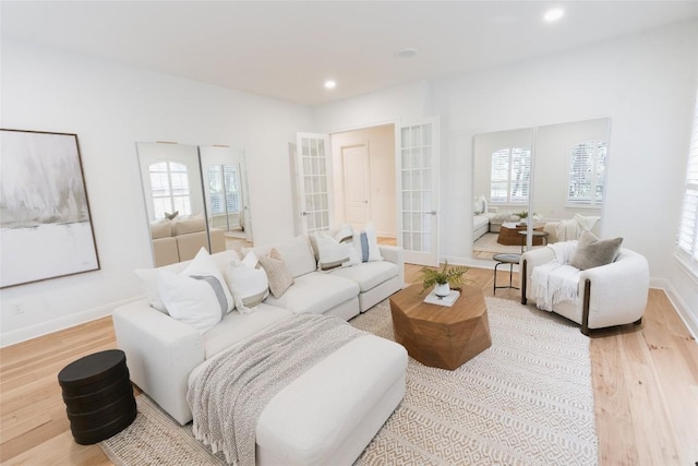 living room with recessed lighting, baseboards, wood finished floors, and a healthy amount of sunlight