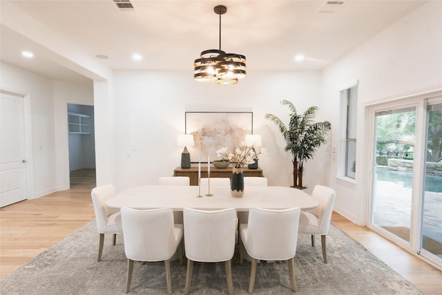 dining space featuring light wood-style floors, a chandelier, and visible vents