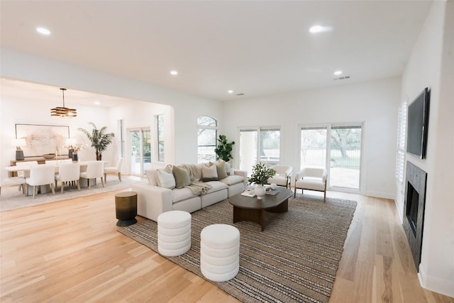 living room with recessed lighting, visible vents, plenty of natural light, and light wood-style flooring