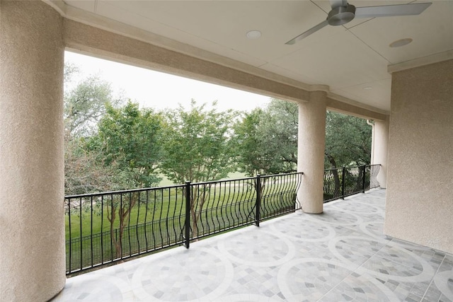 view of patio with ceiling fan and a balcony