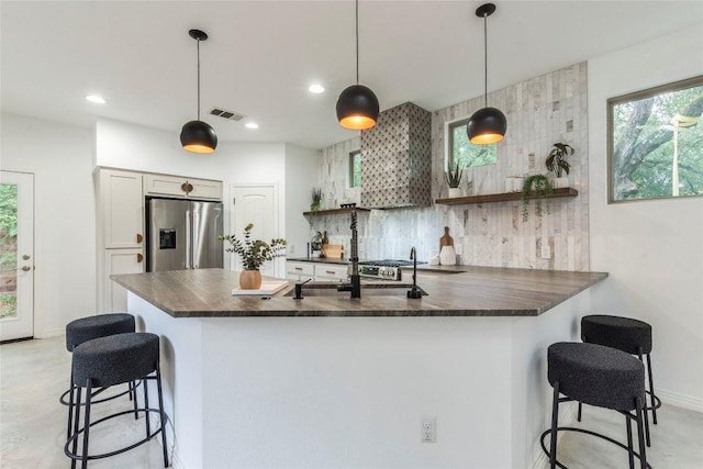 1606 Morgan Ln Unit B, Austin, TX 78704 - kitchen with stainless steel fridge, dark countertops, a kitchen breakfast bar, a peninsula, and decorative backsplash