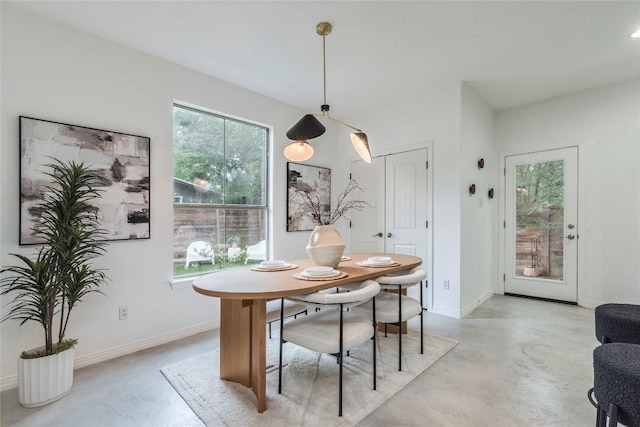 dining area with baseboards and finished concrete flooring