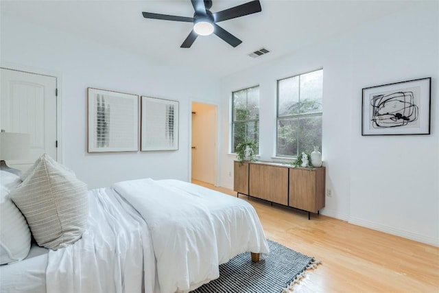bedroom featuring baseboards, ceiling fan, light wood-type flooring, and visible vents