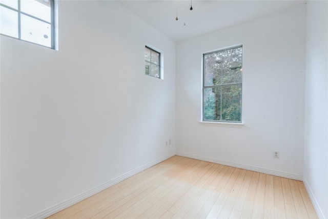 unfurnished room with baseboards and wood finished floors