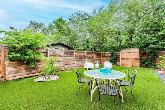 view of yard featuring a fenced backyard and outdoor dining area