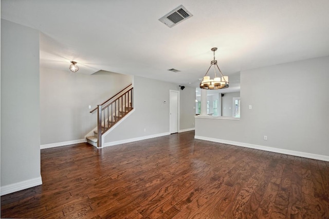 interior space with dark wood-style flooring, a notable chandelier, stairs, baseboards, and visible vents