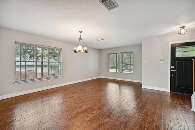 entryway featuring dark wood-type flooring, baseboards, a chandelier, and visible vents