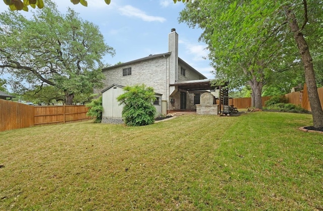 rear view of property featuring a chimney, a lawn, an outbuilding, a fenced backyard, and a shed