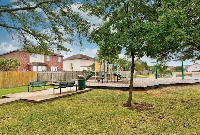 community play area featuring a lawn and fence