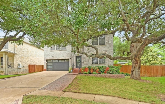 view of front of property with fence, concrete driveway, a front yard, and a garage
