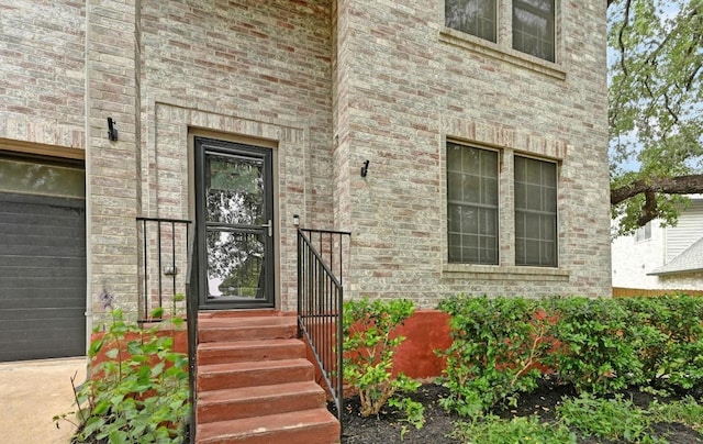 view of exterior entry featuring brick siding