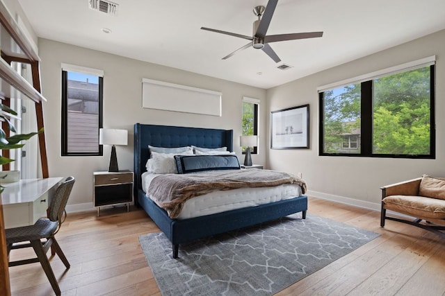 bedroom featuring a ceiling fan, baseboards, visible vents, and light wood-style flooring