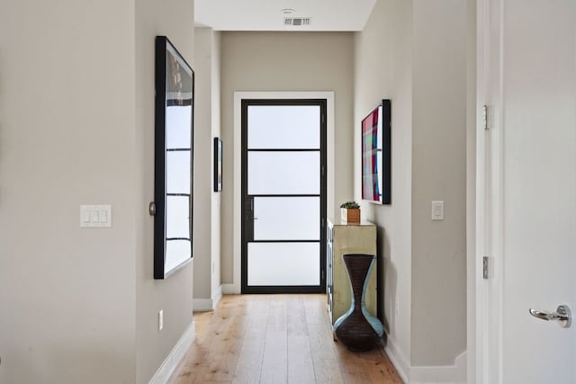 entryway with baseboards, visible vents, and light wood-type flooring