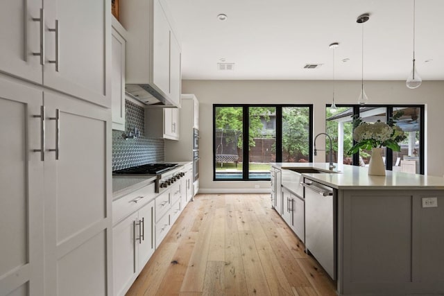kitchen featuring gas cooktop, a sink, light wood-style floors, dishwasher, and visible vents