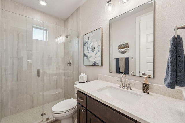 bathroom featuring vanity, a stall shower, and toilet