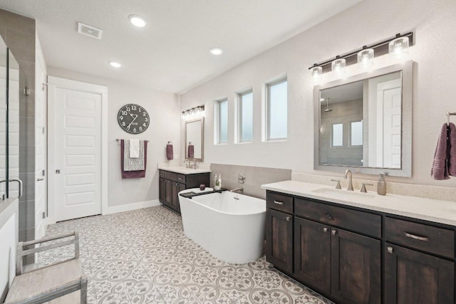 full bath featuring a sink, a freestanding bath, a stall shower, and visible vents