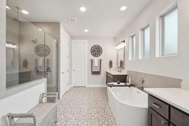 bathroom with a stall shower, vanity, baseboards, a soaking tub, and recessed lighting