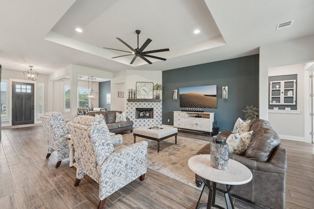 300 Red Mulberry Way, Leander, TX 78641 - living room featuring a tray ceiling, wood finished floors, ceiling fan, a chandelier, and recessed lighting