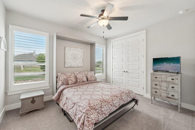 carpeted bedroom featuring baseboards, ceiling fan, and a closet